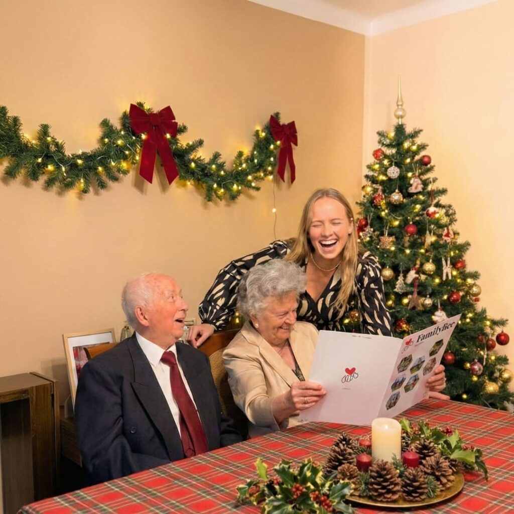 Dziadkowie z wnuczką czytają gazetę rodzinną FamilyBee przy świątecznym stole