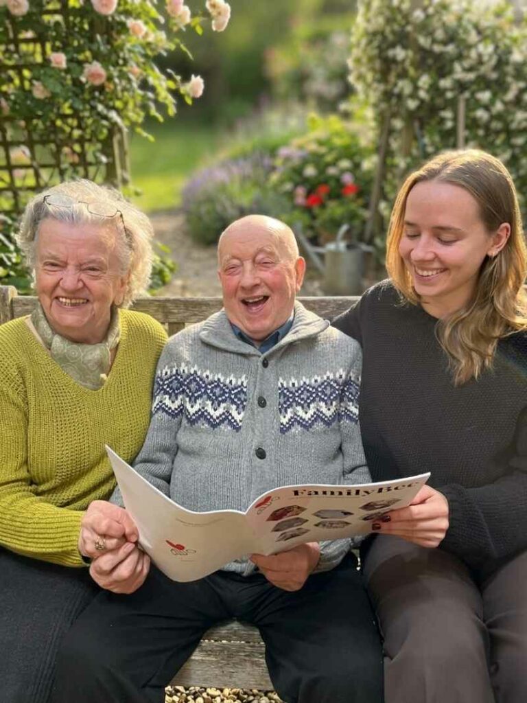 Babcia i dziadek czytają gazetkę FamilyBee razem z wnuczką